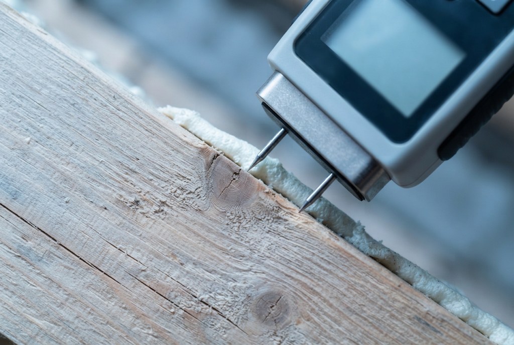 A pin meter on a rafter next to the foam in a Oldham loft.